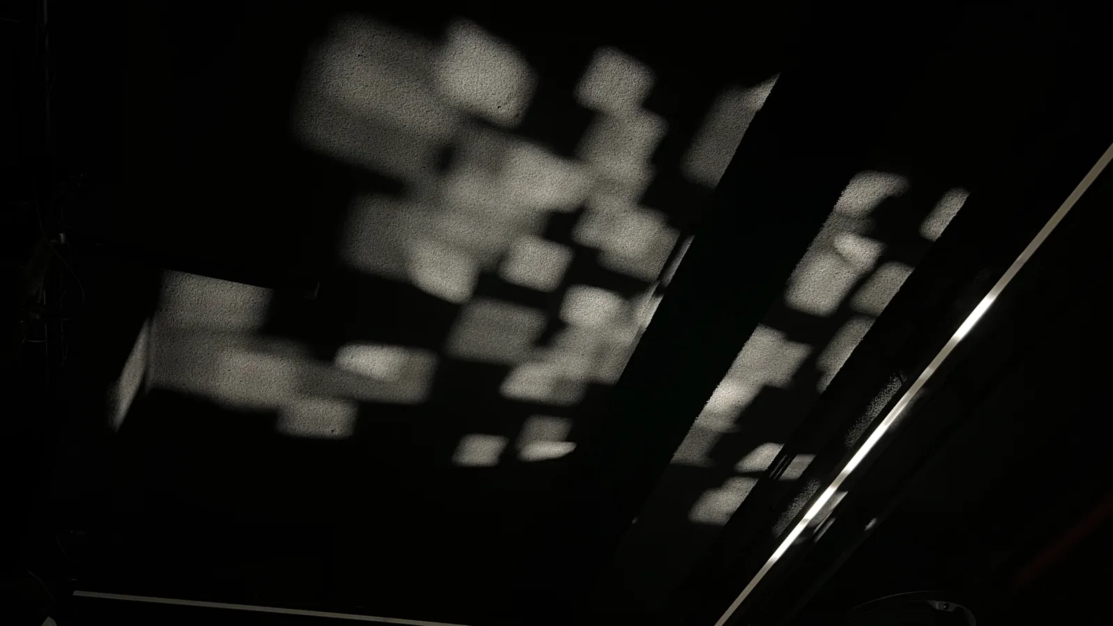 A grid pattern left on the ceiling by the tilted mirrors.